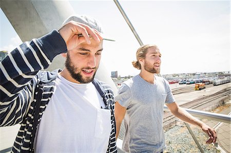 Two young men walking along a bridge. Stock Photo - Premium Royalty-Free, Code: 6118-08129673