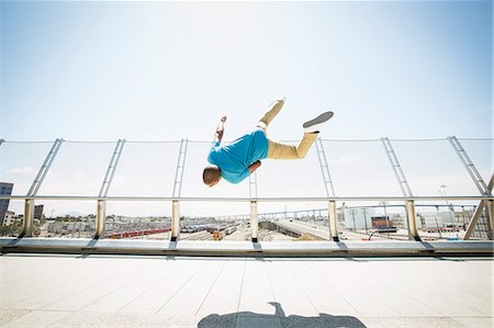 simsearch:6118-08129648,k - Young man somersaulting on a bridge. Foto de stock - Sin royalties Premium, Código: 6118-08129686