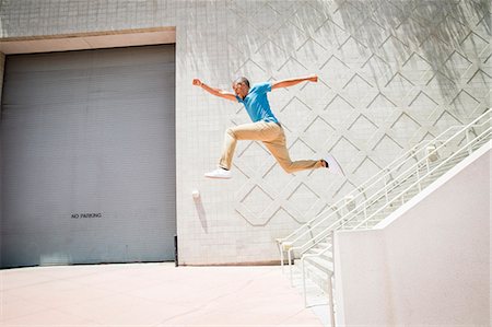 Young man jumping in the air down a stairway. Stock Photo - Premium Royalty-Free, Code: 6118-08129697