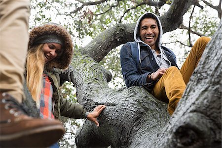 simsearch:6118-08129648,k - Smiling young woman and two young men sitting in a tree. Foto de stock - Sin royalties Premium, Código: 6118-08129627
