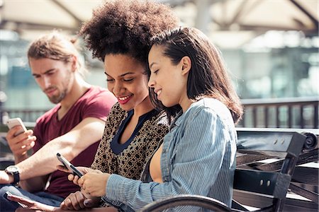 simsearch:6118-08243810,k - Three people seated side by side on a park bench checking their smart phones Stock Photo - Premium Royalty-Free, Code: 6118-08243816