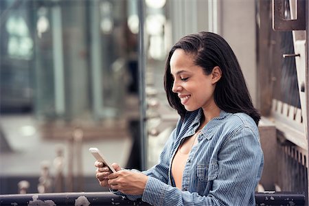 simsearch:6118-08243810,k - A young woman checking her cell phone Stock Photo - Premium Royalty-Free, Code: 6118-08243827