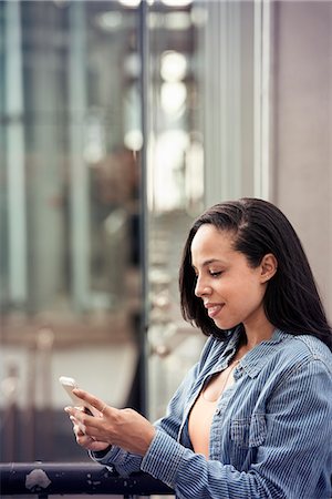 simsearch:6118-08243810,k - A young woman checking her cell phone on a city street Stock Photo - Premium Royalty-Free, Code: 6118-08243826