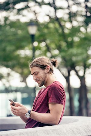 simsearch:6118-08243810,k - A young man in a park checking his cell phone Stock Photo - Premium Royalty-Free, Code: 6118-08243831