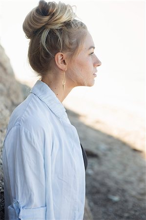 Profile portrait of a blond woman with a hair bun. Stock Photo - Premium Royalty-Free, Code: 6118-08282259