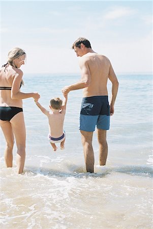 simsearch:649-03667431,k - Couple playing with their son on a sandy beach by the ocean. Stock Photo - Premium Royalty-Free, Code: 6118-08202486