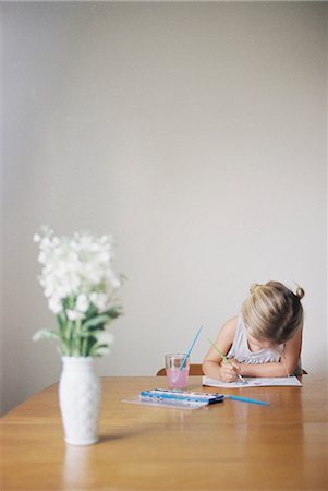 Young girl sitting at  a table, painting, a vase with white flowers. Stock Photo - Premium Royalty-Free, Code: 6118-08202493