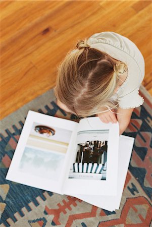 Young girl sitting on the floor, reading a book, view from above Stock Photo - Premium Royalty-Free, Code: 6118-08202504