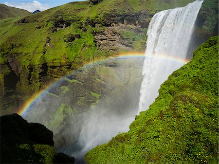 Skogafoss waterfall, a cascade over a sheer cliff, and a rainbow in the mist. Stock Photo - Premium Royalty-Free, Code: 6118-08226992