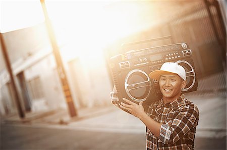 performer - A young man with a boombox on his shoulder on the street of a city. Stock Photo - Premium Royalty-Free, Code: 6118-08393912