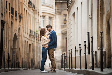 A couple standing gazing at each other, in a narrow street in a city. Stock Photo - Premium Royalty-Free, Code: 6118-08394139