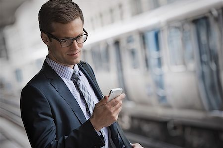 A working day. Businessman in a work suit and tie on a city street, checking his phone. Foto de stock - Sin royalties Premium, Código: 6118-08399594