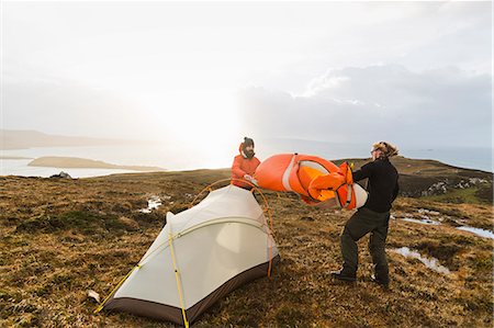 simsearch:6118-08399701,k - Two men holding and putting up a small tent in open space. Wild camping. Stock Photo - Premium Royalty-Free, Code: 6118-08399681