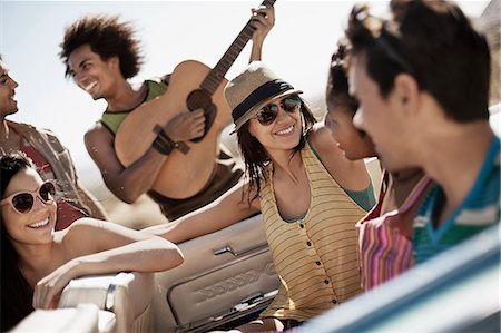 A group of friends in a pale blue convertible on the open road, driving across a dry flat plain surrounded by mountains. Photographie de stock - Premium Libres de Droits, Code: 6118-08488162