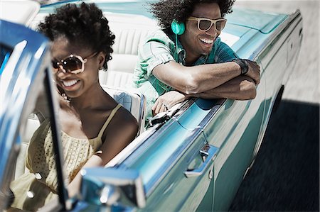A young couple, man and woman in a pale blue convertible on the open road Photographie de stock - Premium Libres de Droits, Code: 6118-08488182
