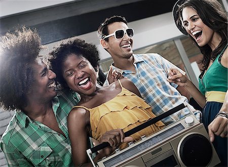 simsearch:6118-08140197,k - Four friends with a large portable music player, having a party. Stock Photo - Premium Royalty-Free, Code: 6118-08488219