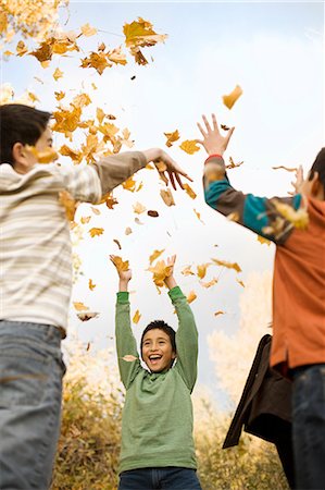 fall leaves teenagers - A group of children, young people, throwing fallen autumn leaves into the air. Stock Photo - Premium Royalty-Free, Code: 6118-08488365