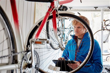 self-employed - A young man working in a cycle shop, repairing a bicycle. Stock Photo - Premium Royalty-Free, Code: 6118-08488458