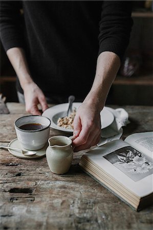 simsearch:6118-08521776,k - A person at a table with a cup of coffee, bowl of muesli and an open book. Stock Photo - Premium Royalty-Free, Code: 6118-08521783