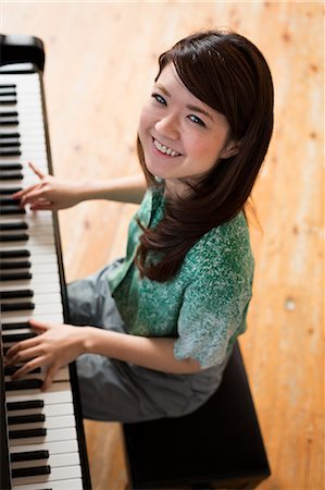 simsearch:640-01365707,k - Young woman playing on a grand piano in a rehearsal studio. Stock Photo - Premium Royalty-Free, Code: 6118-08659943