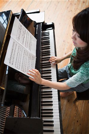 simsearch:640-01365707,k - Young woman playing on a grand piano in a rehearsal studio. Stock Photo - Premium Royalty-Free, Code: 6118-08659942