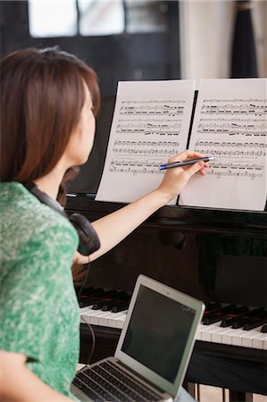 piano practice - Young woman sitting at a grand piano in a rehearsal studio, annotating sheet music. Stock Photo - Premium Royalty-Free, Code: 6118-08659961