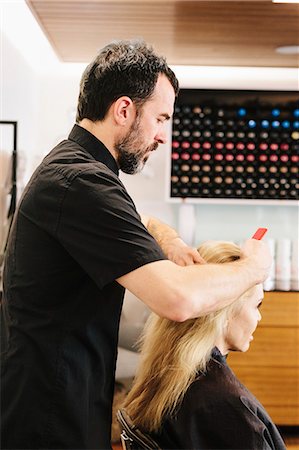 simsearch:6118-08660009,k - A hair stylist combing out a client's hair. Stock Photo - Premium Royalty-Free, Code: 6118-08660006
