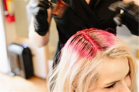 simsearch:6118-08660009,k - A hair colourist in gloves applying red hair dye to a client's blonde hair with a brush. Stock Photo - Premium Royalty-Free, Code: 6118-08660011