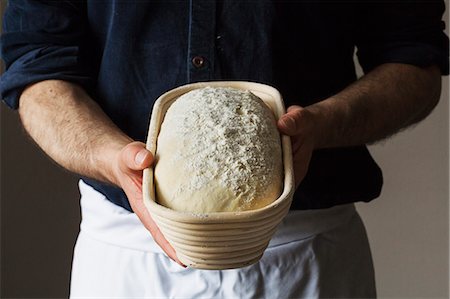 retailer - Close up of a baker holding a freshly baked loaf of white bread in a rattan proofing basket. Stock Photo - Premium Royalty-Free, Code: 6118-08660026