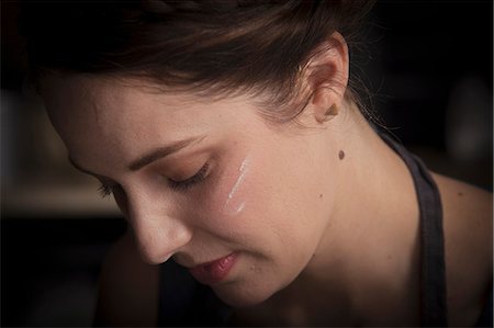 stain (dirty) - Valentine's Day baking, close up portrait of a young woman with flour on her cheek. Stock Photo - Premium Royalty-Free, Code: 6118-08660184