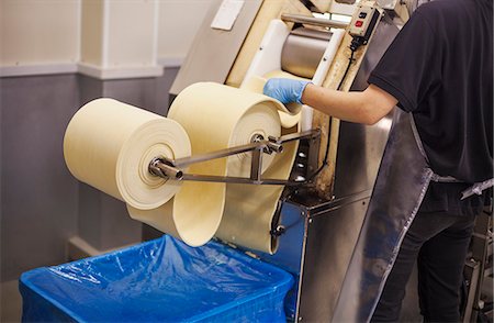 A Soba noodle factory.  Sheets of fresh noodle dough being passed through a large pressing machine. Stock Photo - Premium Royalty-Free, Code: 6118-08762031