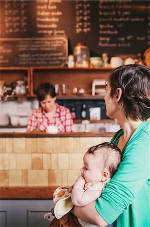simsearch:6118-08660009,k - Two women, a same sex couple with their 6 month old baby in their coffee shop. business owners and parents. Stock Photo - Premium Royalty-Free, Code: 6118-08725455