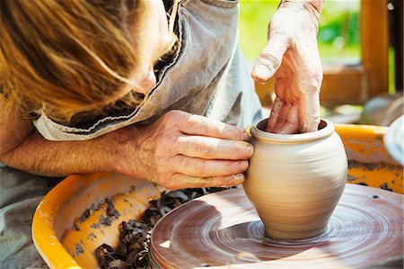 pottery - A woman potter working clay on a potter's wheel in her workshop. Stock Photo - Premium Royalty-Free, Code: 6118-08725946