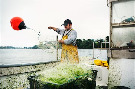 fishnet - A fisherman standing on a boat throwing the floats out to spread the net over the water. Stock Photo - Premium Royalty-Free, Code: 6118-08726033