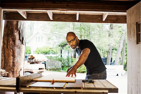 Man wearing glasses working in a lumber yard. Stock Photo - Premium Royalty-Free, Code: 6118-08729355