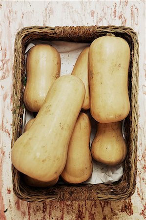 simsearch:6118-07808971,k - A shot of a pile of butternut squash in a basket on a wooden surface, seen from above. Stock Photo - Premium Royalty-Free, Code: 6118-08842018