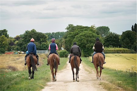 simsearch:6102-08542382,k - A string or group of riders on thoroughbred horses riding along a path. Racehorses in training. Routine exercise. Stock Photo - Premium Royalty-Free, Code: 6118-08882891