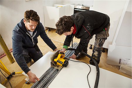 Two builders, cutting plasterboard with a circular saw. Stock Photo - Premium Royalty-Free, Code: 6118-08947497