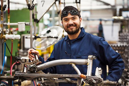 Male skilled factory worker with a partly assembled bicycle frame in a factory. Stock Photo - Premium Royalty-Free, Code: 6118-08947614