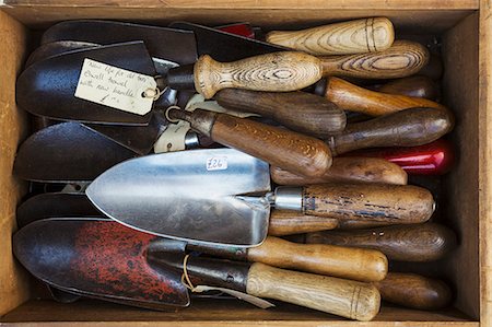 Overhead view of a collection of handheld garden forks, with metal tines and smooth wooden handles. Stock Photo - Premium Royalty-Free, Code: 6118-08947807