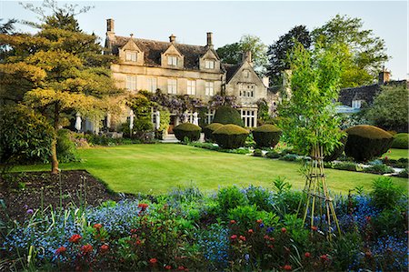 platebandes de fleur - Exterior view of a 17th century historic Cotswolds country house from a garden with flower beds, shrubs and trees. Photographie de stock - Premium Libres de Droits, Code: 6118-08971530