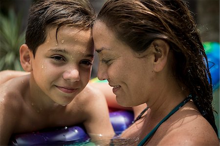 simsearch:695-03374346,k - A woman and a boy cuddling in a swimming pool. Stock Photo - Premium Royalty-Free, Code: 6118-08991485