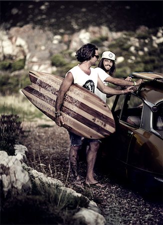 Two young men standing next to car, carrying surfboard. Photographie de stock - Premium Libres de Droits, Code: 6118-08991408