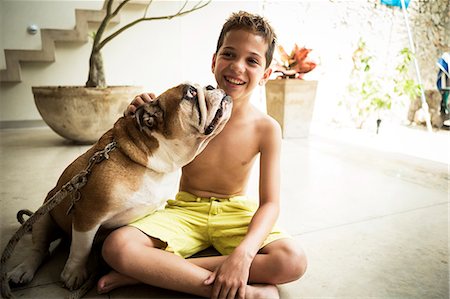 dog lick - A boy and a dog sitting on the floor together. Photographie de stock - Premium Libres de Droits, Code: 6118-08991504