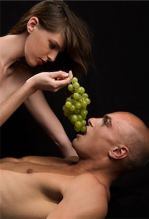 Nude couple, woman feeding man with green grapes. Stock Photo - Premium Royalty-Free, Code: 6118-08928175