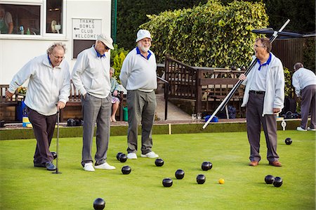 sports venue - Four men on the lawn bowls green, one wearing an umpire's coat, at an end. Stock Photo - Premium Royalty-Free, Code: 6118-09059661