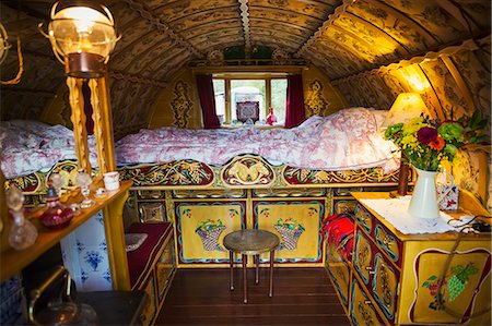 folk art - The interior of a traditional gypsy caravan with raised bed and cupboards, bow top roof and stove. Stock Photo - Premium Royalty-Free, Code: 6118-09059620