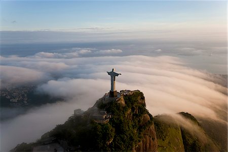 High angle view of colossal Christ Redeemer statue surrounded by clouds, Corcovado, Rio de Janeiro, Brazil. Stock Photo - Premium Royalty-Free, Code: 6118-09076419