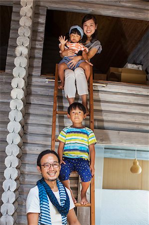 Family, man, woman, boy and young girl sitting on a ladder, smiling at camera. Stock Photo - Premium Royalty-Free, Code: 6118-09079283