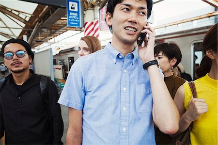 simsearch:6113-07961592,k - Small group of people standing on the platform of a subway station, Tokyo commuters, man using smartphone. Foto de stock - Sin royalties Premium, Código: 6118-09079690